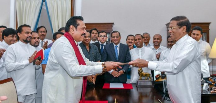Sri Lanka's former President Rajapaksa is sworn in as the Prime Minister before President Sirisena in Colombo