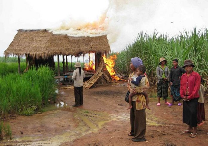 topic 5. people watch a community building burn next to a sugar plantation belonging to thailands mitr phol sugar corporation in oddar meanchey in 2009 by supplied 1